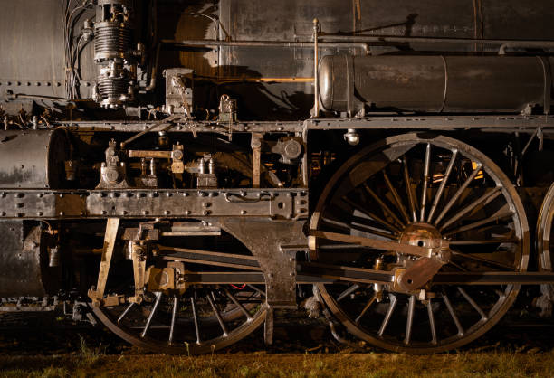 歴史的な蒸気機関車、夜間に点灯する車輪とロッドのクローズアップ - collectors car antiquities ancient past ストックフォトと画像