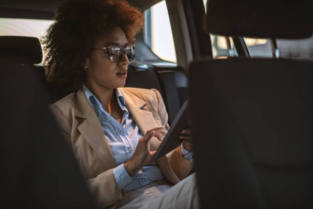 istock Business woman using digital tablet in a car 1182301298