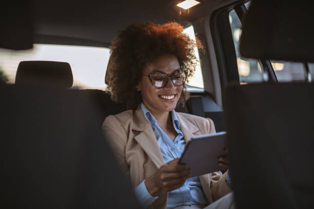istock Business woman using digital tablet in a car 1182301355