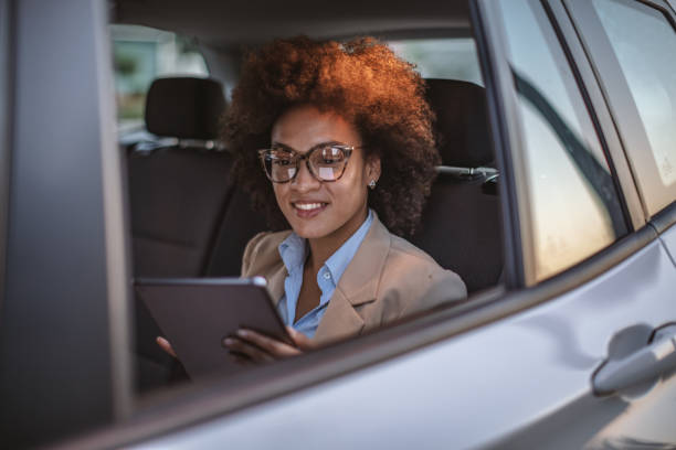istock Business woman using digital tablet in a car 1182301415
