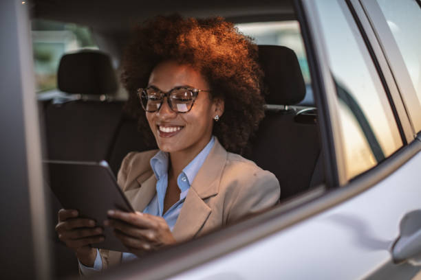 istock Business woman using digital tablet in a car 1182301459