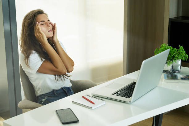 istock Woman with headache in office 1182301492