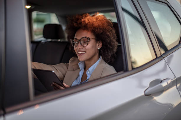istock Business woman using digital tablet in a car 1182301560