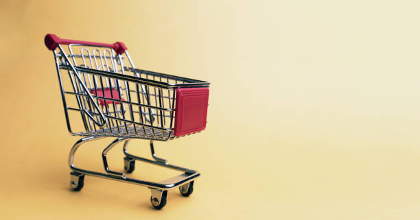 istock Empty shopping cart on yellow background 1182306117