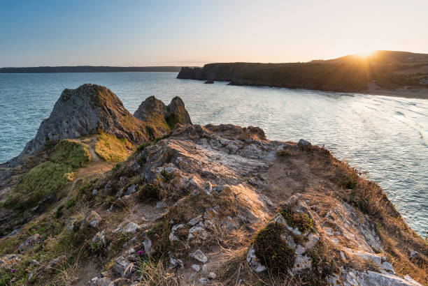istock Beautiful peaceful Summer evening sunset beach landscape image at Three Cliffs Bay in South Wales 1182306397