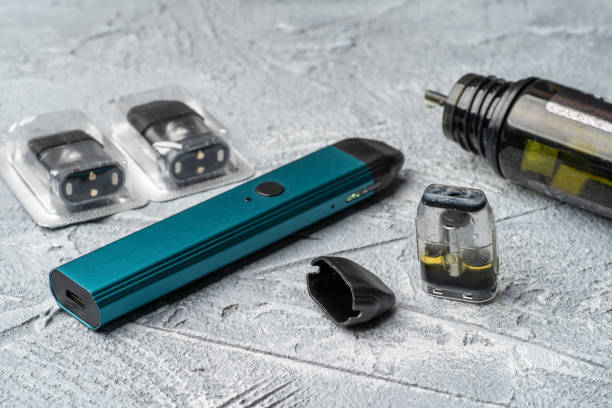 vape pod system and replacement cartridges filled with e-juice or liquid with salt nicotine, new vape pen device, close up - pod imagens e fotografias de stock