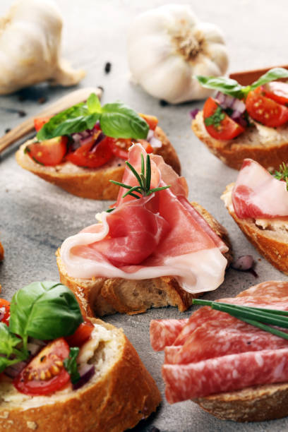 istock Assorted bruschetta with various toppings. Appetizing bruschetta or crudo crostini. Variety of small sandwiches. Mix bruschetta on table 1182309912