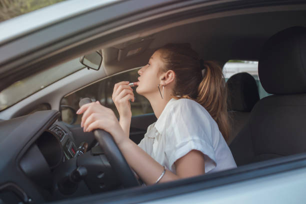 chica joven está poniendo lápiz labial en el atasco de tráfico en el día lluvioso - traffic jam traffic sports utility vehicle car fotografías e imágenes de stock