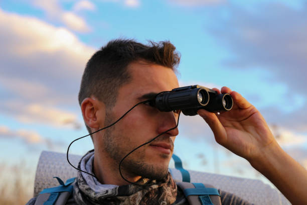 istock young traveler man watching nature with binoculars 1182314042