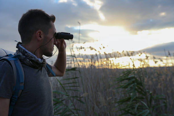 istock young traveler man watching nature with binoculars 1182314083