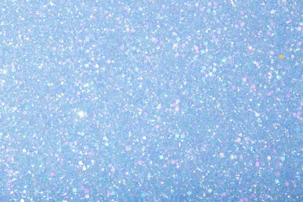 Holographic bright light blue glitter real texture background.