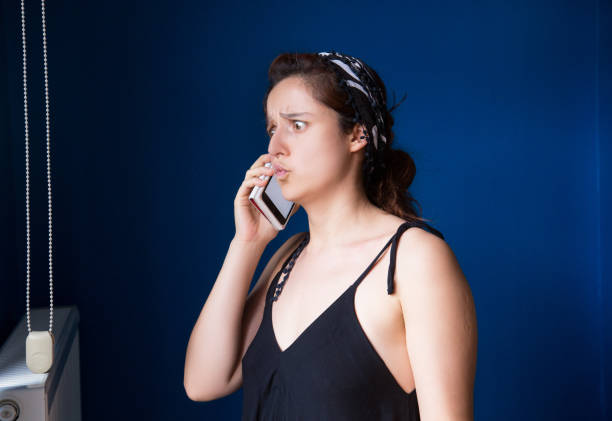 istock Angry Woman looking out window talking on phone 1182317651