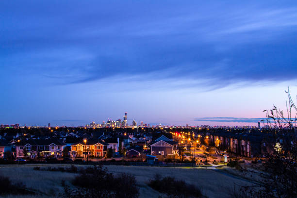 A wide view from the scenic park hill in the newly developed Griesbach community of Downtown Edmonton in the early night. The street lights just came on. The clouds in the sky looks beautiful, and there is still a slight pink left from the sunset.