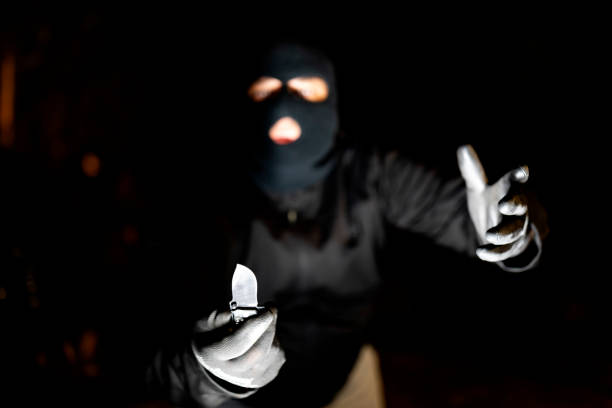 bandit with knife on dark background - aggression control clothing image type imagens e fotografias de stock