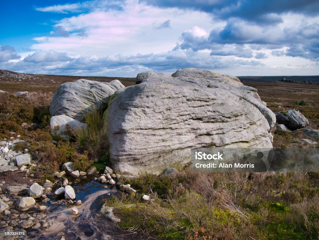 Eroded millstone boulders near Simon's Seat on Barden Fell in the Yorkshire Dales, England, UK Eroded millstone boulders near Simon's Seat on Barden Fell in the Yorkshire Dales, England, UK - taken on a sunny day in Autumn, with moorland heather in the foreground. Blue Stock Photo