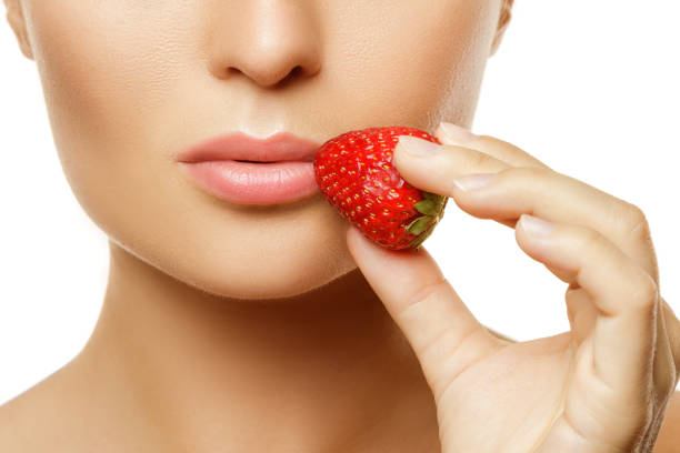 istock Female lips and strawberry 1182324638