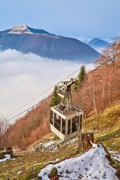 Funicular cable way near mountain hill against autumnforest and top mountains. Winter landscape. Mountain forest landscape. Travel background. Winter hiking ski mountain