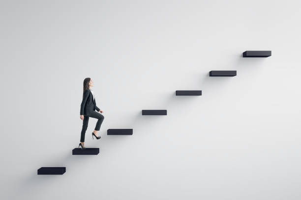 Leadership and career development concept Side view of young businesswoman climbing stairs to success on concrete wall background. Leadership and career development concept stepping forward stock pictures, royalty-free photos & images