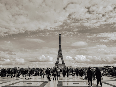 eiffel tower in day time with cloudy sky and full of tourist