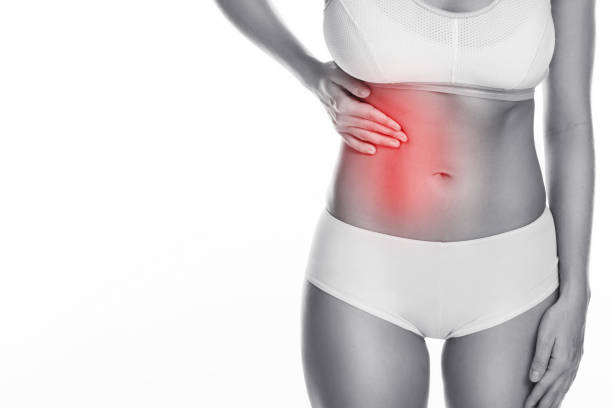 Woman is feeling pain under her ribs Woman is feeling pain under her ribs. Liver problem. Isolated on white background female rib cage stock pictures, royalty-free photos & images
