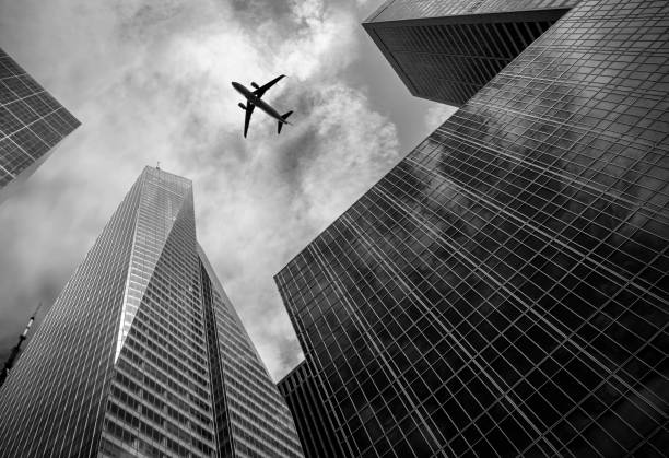 Low angle view of modern skyscrapers with a airplane silhouette