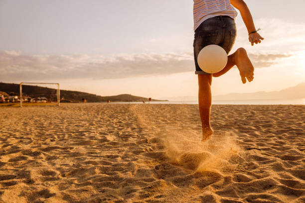 istock Boy playing soccer on the beach 1182330727