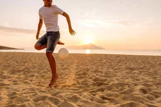 istock Boy playing soccer on the beach 1182330769