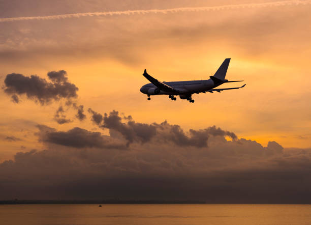 istock Passenger airplane flying above clouds during sunset 1182333073