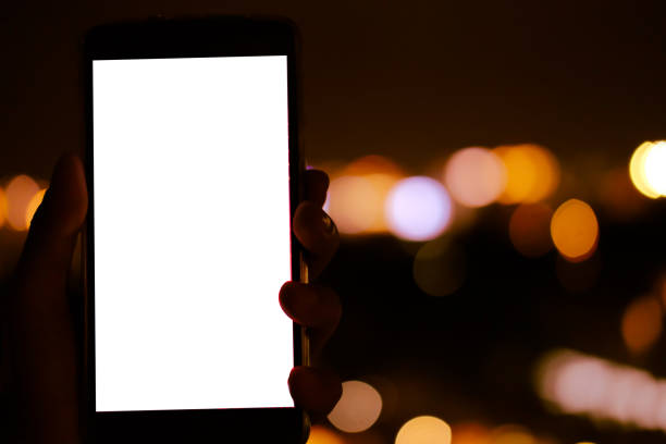 istock hand holding mobile smart phone with bokeh night light 1182341404