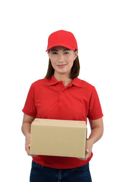 istock Smiling delivery woman in red uniform giving parcel boxes, isolated on white background 1182343042