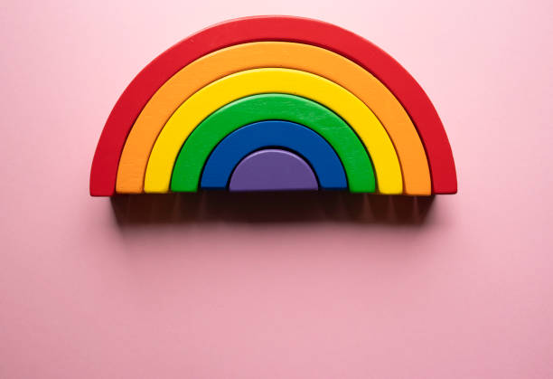 istock Bright wooden rainbow toy on a pink background with copy space at the bottom - creative flat lay composition 1182343815