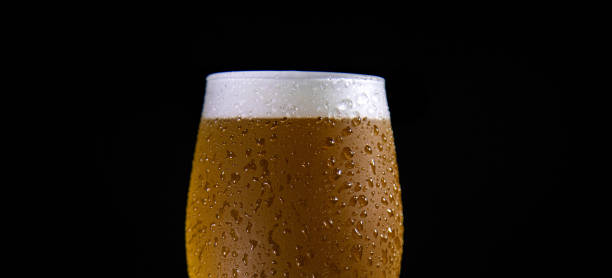 gotas en detalle de cerveza recién vertida macro deliciosa desenfocada - condensate fotografías e imágenes de stock