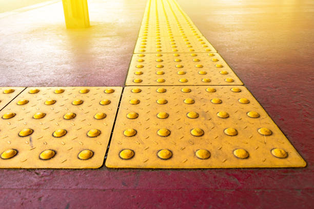 istock rough yellow dot tactile paving for blind handicap on tiles pathway in japan, walkway for blindness people. 1182356708