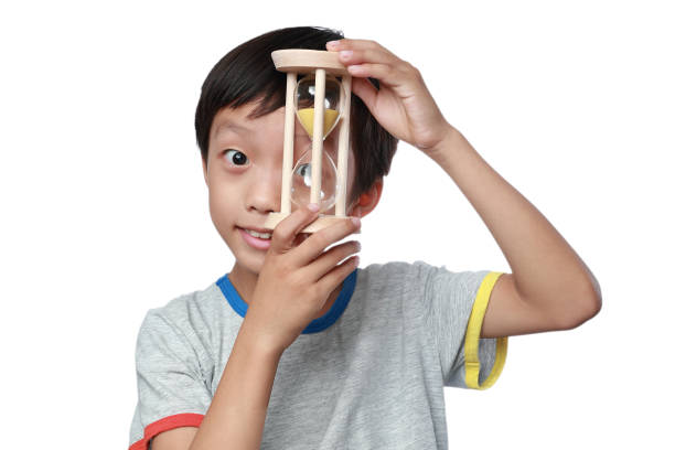 Boy Looking At Hourglass At Home