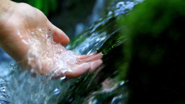 Touching a clear stream water