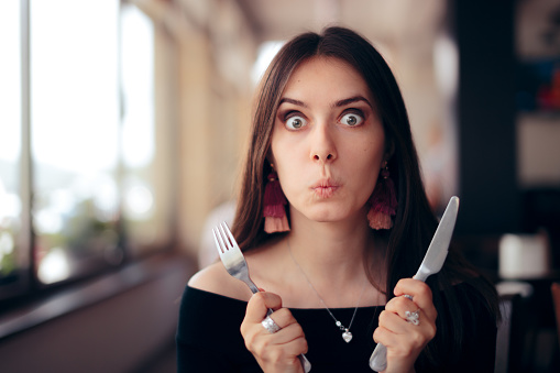 Mujer Hambrienta con Cuchillo y Tenedor Listo para Comer photo