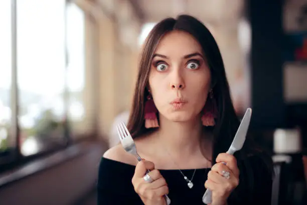 Photo of Hungry Woman with Knife and Fork Ready to Eat