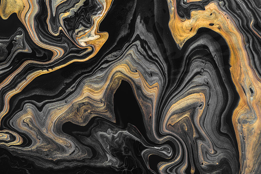 Black marble background with golden waves and curls. Abstract background or texture. Acrylic Fluid Art.