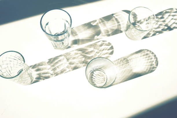 top view of glasses  set and shadows on white surface. flat lay