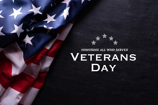 Feliz Día de los Veteranos. Banderas americanas con el texto gracias veteranos contra un fondo de pizarra. 11 de noviembre. photo