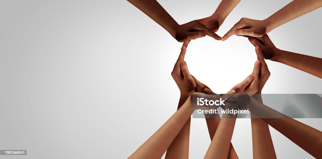 Unity And Diversity Unity and diversity partnership as heart hands in a group of diverse people connected together shaped as a support symbol expressing the feeling of teamwork and togetherness. Hand Stock Photo