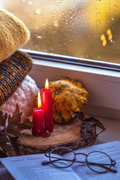 istock Autumn composition on a windowsill reading a book on a rainy evening. 1182368821