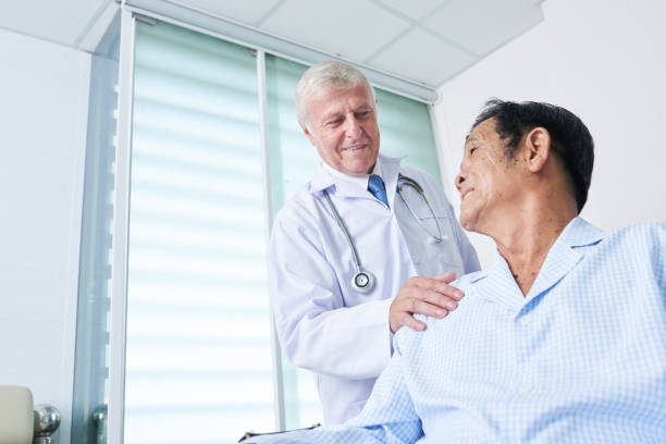 istock General practitioner patting shoulder of senior patient 1182369970