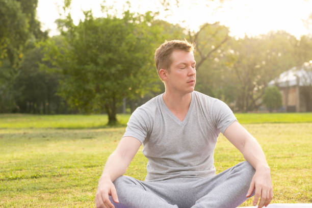 istock Young handsome man relaxing with eyes closed at the park 1182370099