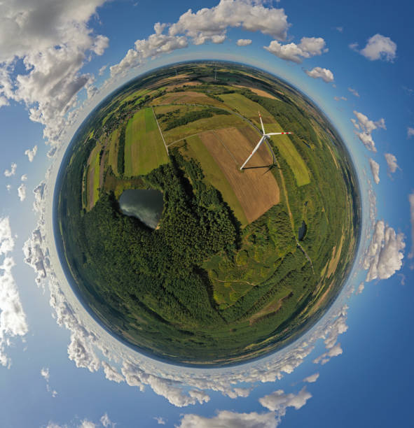 istock Aerial drone 360 degree view on wind turbine, snake shape road, wheat fields and forest during summer 1182371020
