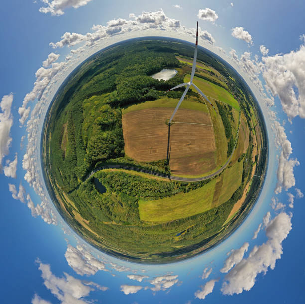istock Aerial drone 360 degree view on wind turbine, snake shape road, wheat fields and forest during summer 1182371042