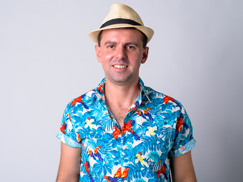 Studio shot of tourist man ready for vacation against white background
