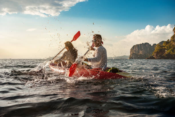 glückliches paar mit spaß und spaziergänge auf kajaks - kayaking kayak sea coastline stock-fotos und bilder