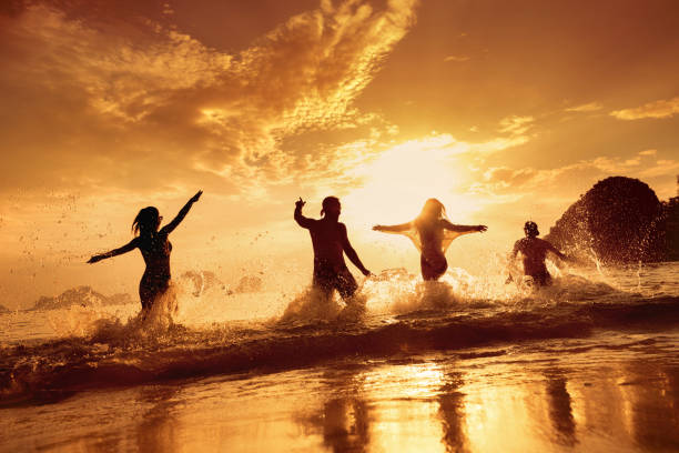 istock Happy friends run and having fun at sunset beach 1182376094