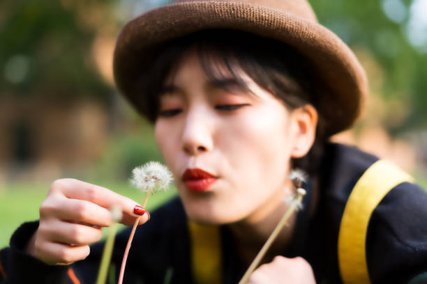 istock Girl blowing dandelion 1182376350